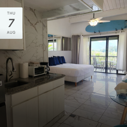 Bright, modern studio apartment with a balcony and kitchen.